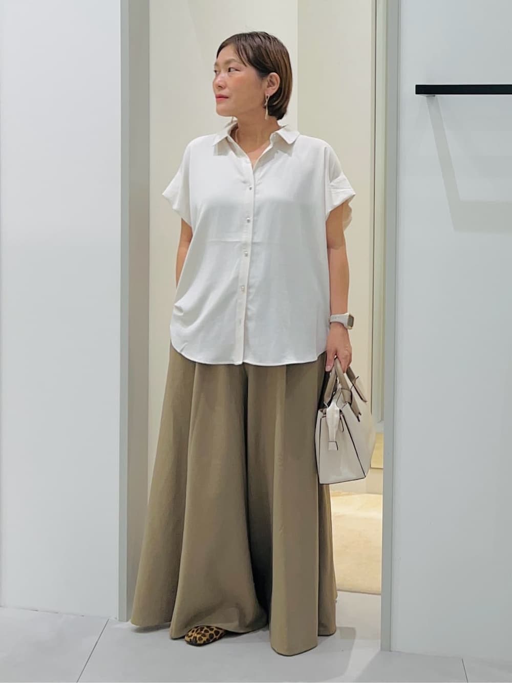 ホワイト系のシャツ/ブラウス、ベージュ系のその他パンツ、ホワイト系のショルダーバッグを着用したレディースの秋コーディネートの1枚目の写真