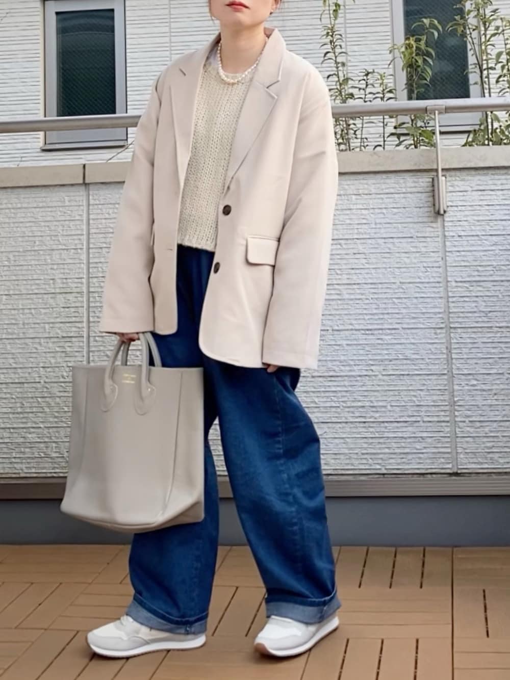 ホワイト系のテーラードジャケット、ホワイト系のニット/セーター、ブルー系のその他パンツを着用したレディースの冬コーディネートの1枚目の写真