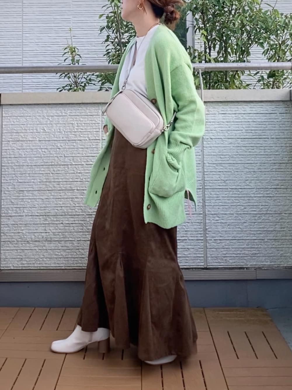 グリーン系のカーディガン/ボレロ、ブラウン系のスカート、ブラウン系のショルダーバッグを着用したレディースの秋コーディネートの1枚目の写真