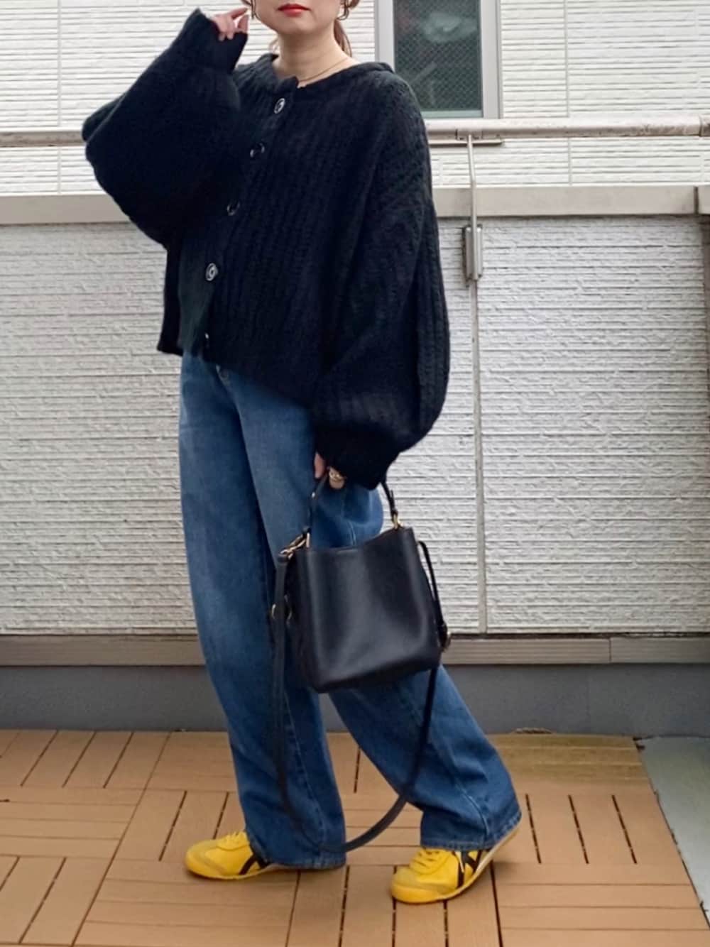 ブラック系のカーディガン/ボレロ、ブルー系のデニムパンツ、ブラック系のショルダーバッグを着用したレディースの秋コーディネートの1枚目の写真