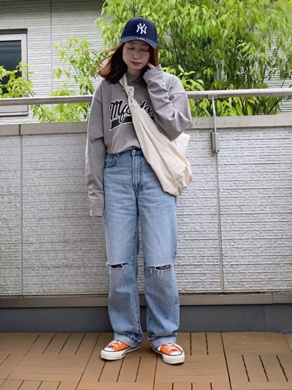 グレー系のTシャツ/カットソー、ブルー系のデニムパンツ、ホワイト系のショルダーバッグを着用したレディースの春コーディネートの1枚目の写真