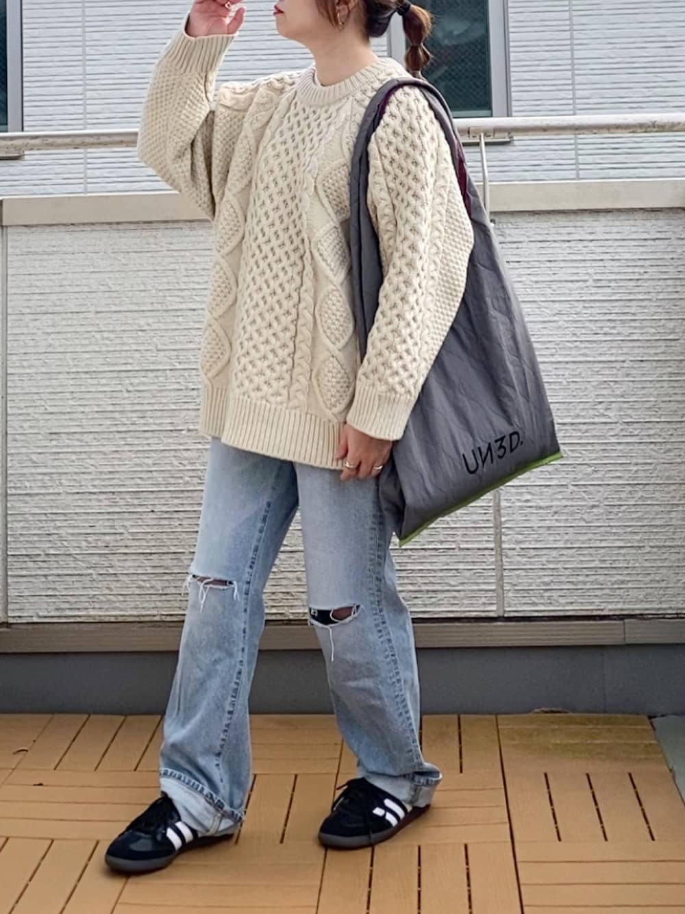 ホワイト系のニット/セーター、ブルー系のデニムパンツ、グレー系のトートバッグを着用したレディースの秋コーディネートの1枚目の写真