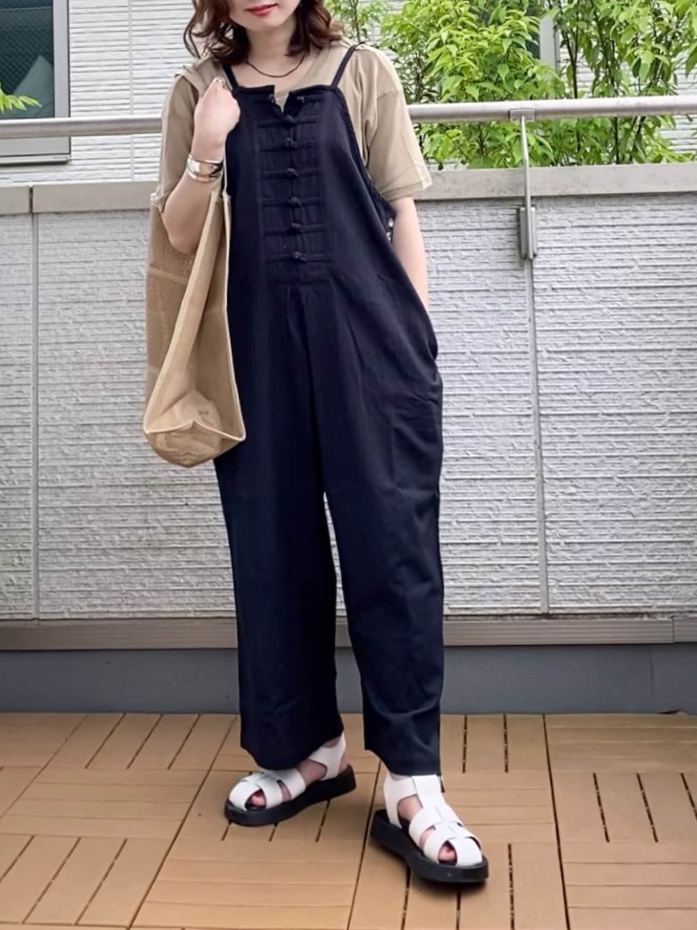ブラック系のサロペット/オーバーオール、ベージュ系のTシャツ/カットソー、ベージュ系のエコバッグ/サブバッグを着用したレディースの夏コーディネートの1枚目の写真