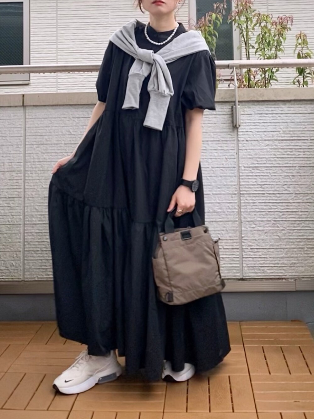 ブラック系のワンピース、グレー系のカーディガン/ボレロ、グリーン系のショルダーバッグを着用したレディースの春コーディネートの1枚目の写真