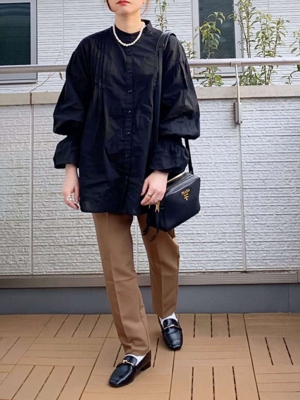 ブラック系のシャツ/ブラウス、ブラウン系のその他パンツ、ブラック系のローファーを着用したレディースの春コーディネートの1枚目の写真