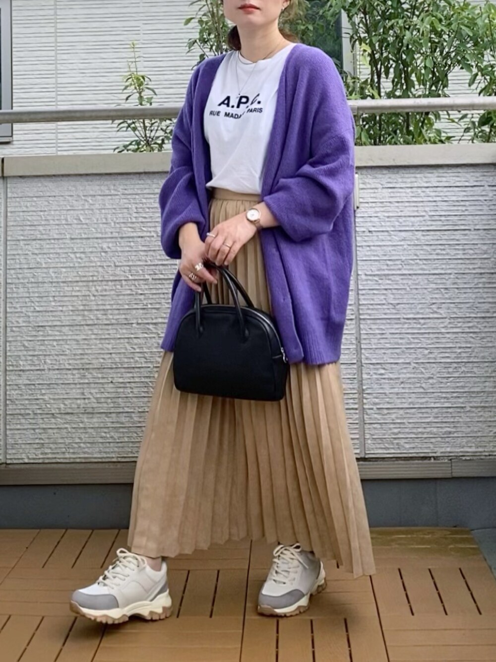 パープル系のカーディガン/ボレロ、イエロー系のスカート、ブラック系のショルダーバッグを着用したレディースの秋コーディネートの1枚目の写真