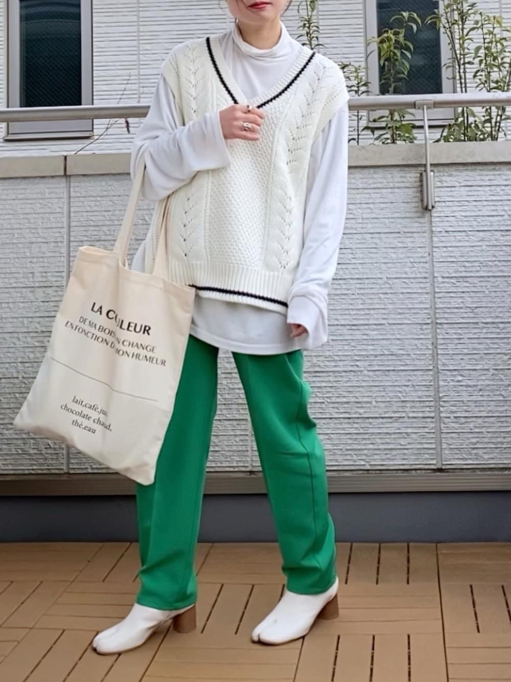 ホワイト系のベスト、グリーン系のその他パンツ、ホワイト系のトートバッグを着用したレディースの春コーディネートの1枚目の写真