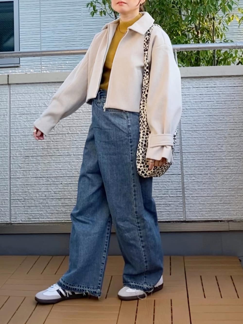 ホワイト系のブルゾン、イエロー系のニット/セーター、ホワイト系のトートバッグを着用したレディースの秋コーディネートの1枚目の写真