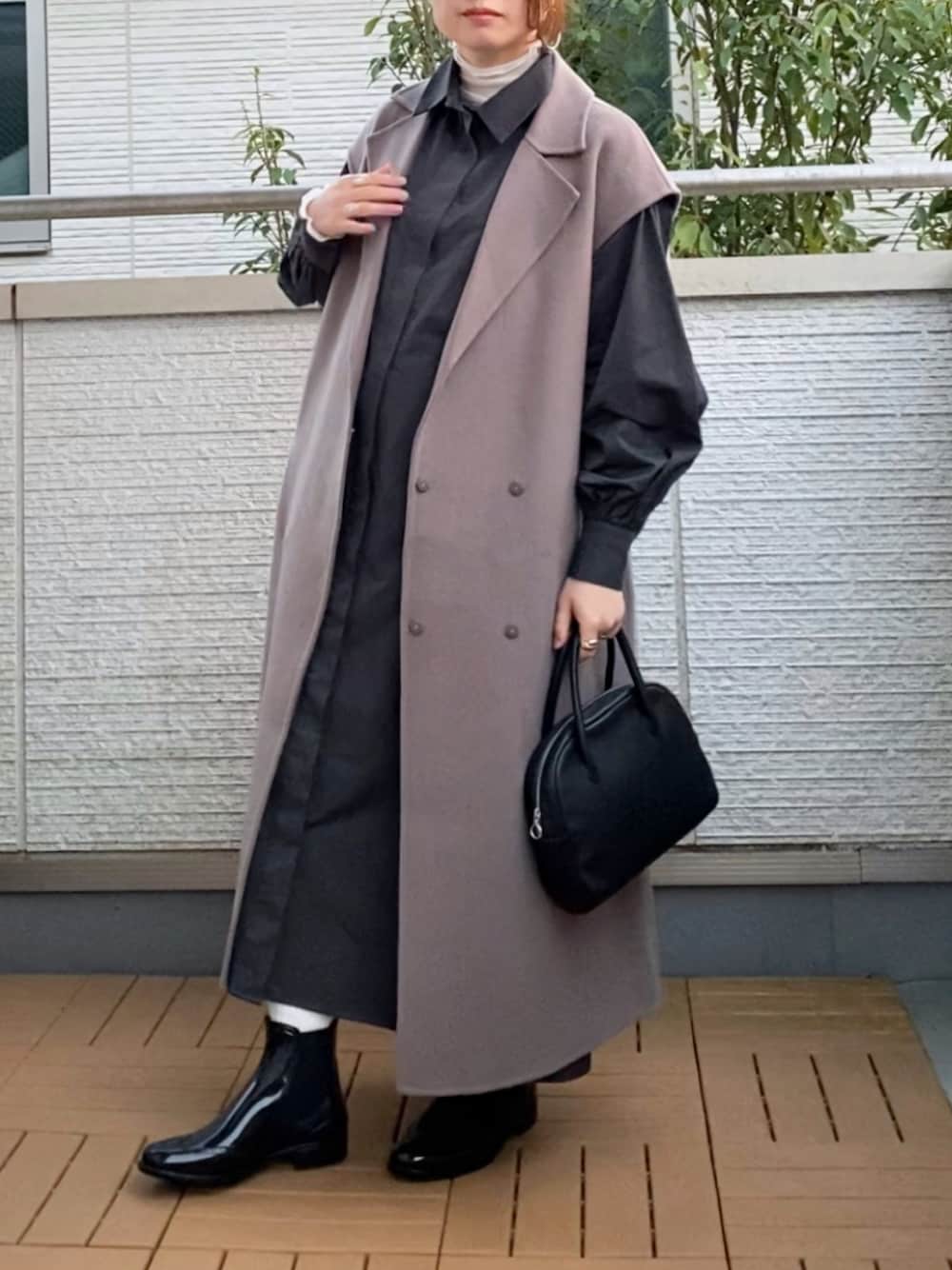 ブラウン系のチェスターコート、グレー系のシャツワンピース、ホワイト系のTシャツ/カットソーを着用したレディースの秋コーディネートの1枚目の写真