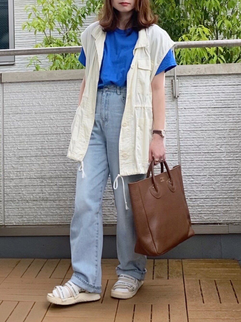 ブルー系のTシャツ/カットソー、ホワイト系のベスト、ブルー系のデニムパンツを着用したレディースの春コーディネートの1枚目の写真