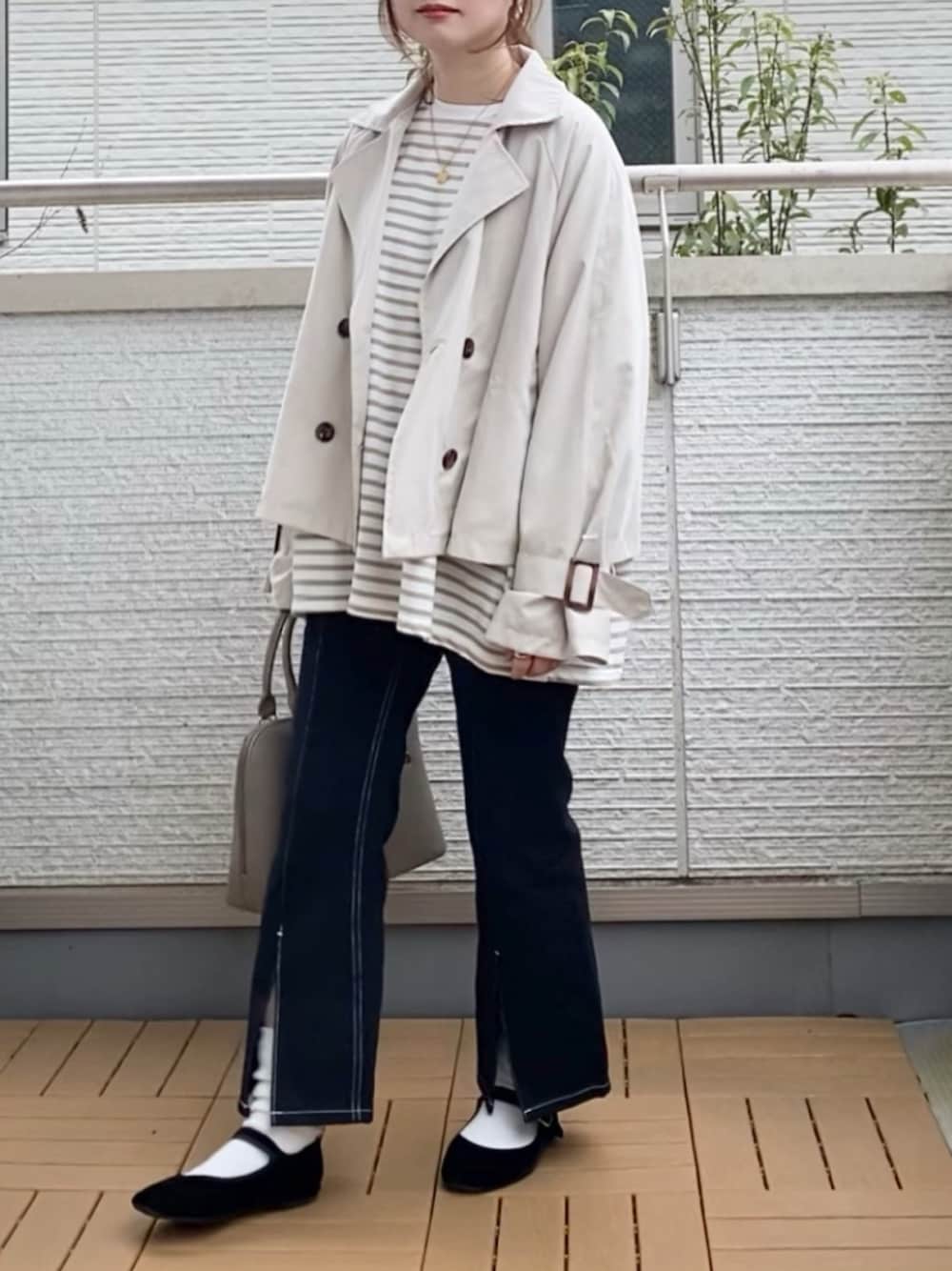ホワイト系のトレンチコート、ベージュ系のTシャツ/カットソー、ブラック系のデニムパンツを着用したレディースの春コーディネートの1枚目の写真