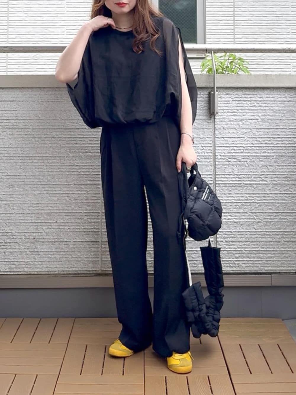 ブラック系のシャツ/ブラウス、ブラック系のスラックス、ブラック系のショルダーバッグを着用したレディースの夏コーディネートの1枚目の写真