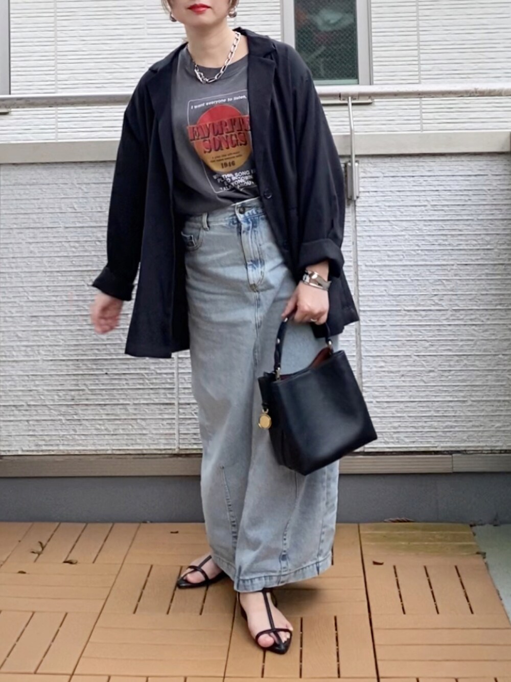 ブラック系のショルダーバッグ、ブラック系のテーラードジャケット、ブラック系のTシャツ/カットソーを着用したレディースの秋コーディネートの1枚目の写真