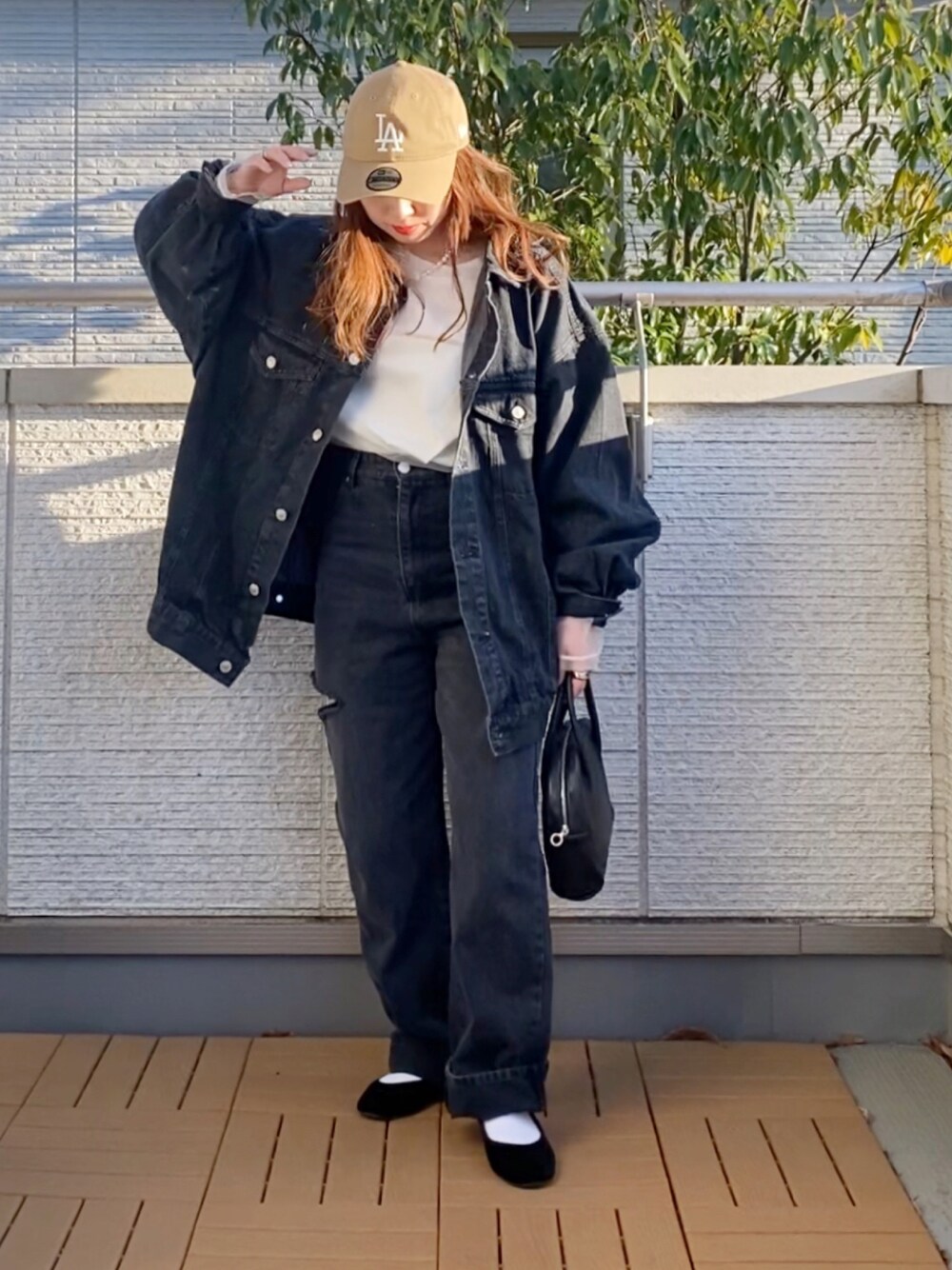 ブラック系のデニムジャケット、ホワイト系のTシャツ/カットソー、ブラック系のデニムパンツを着用したレディースの春コーディネートの1枚目の写真