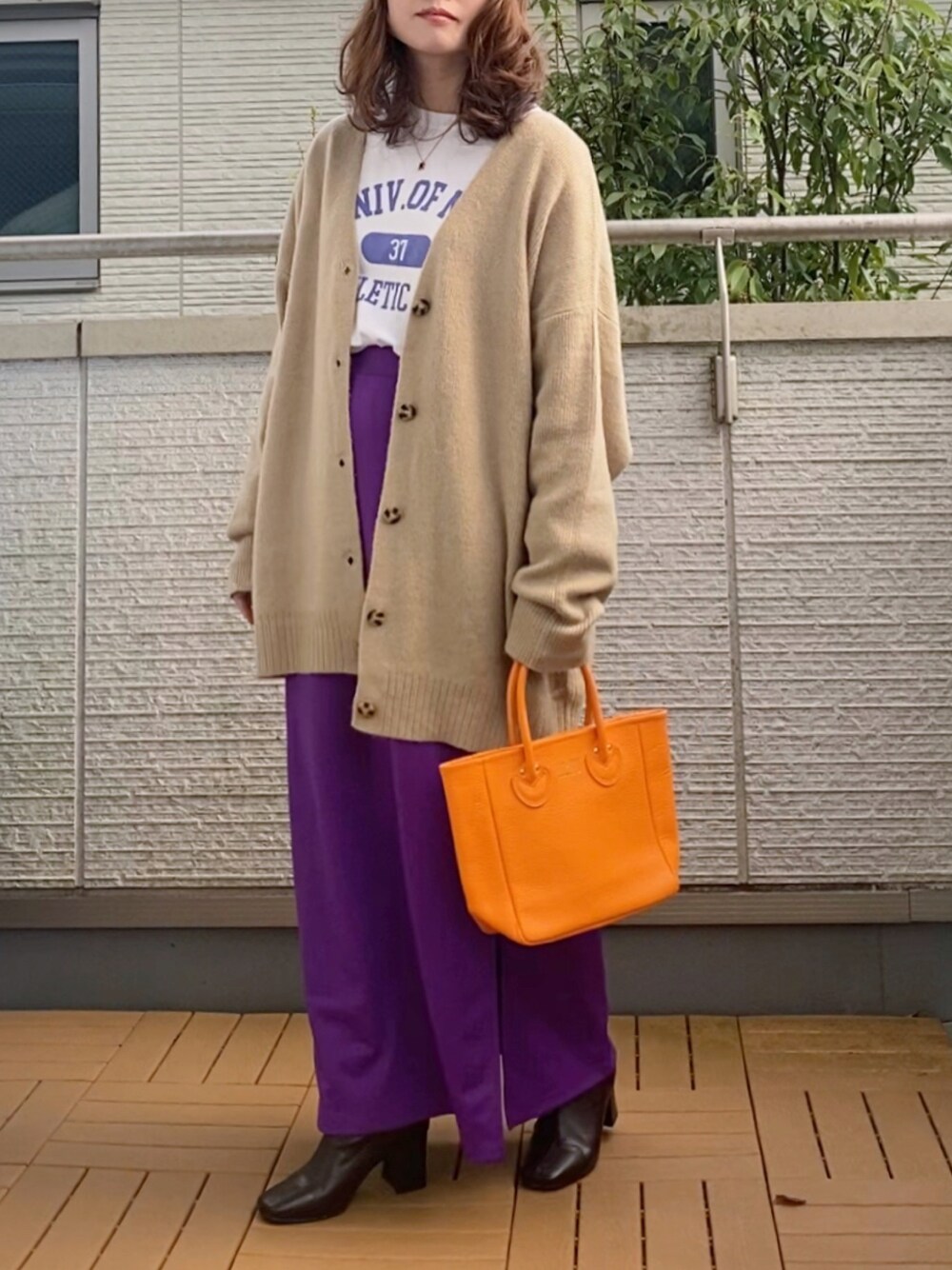 ベージュ系のカーディガン/ボレロ、ホワイト系のTシャツ/カットソー、パープル系のスカートを着用したレディースの秋コーディネートの1枚目の写真