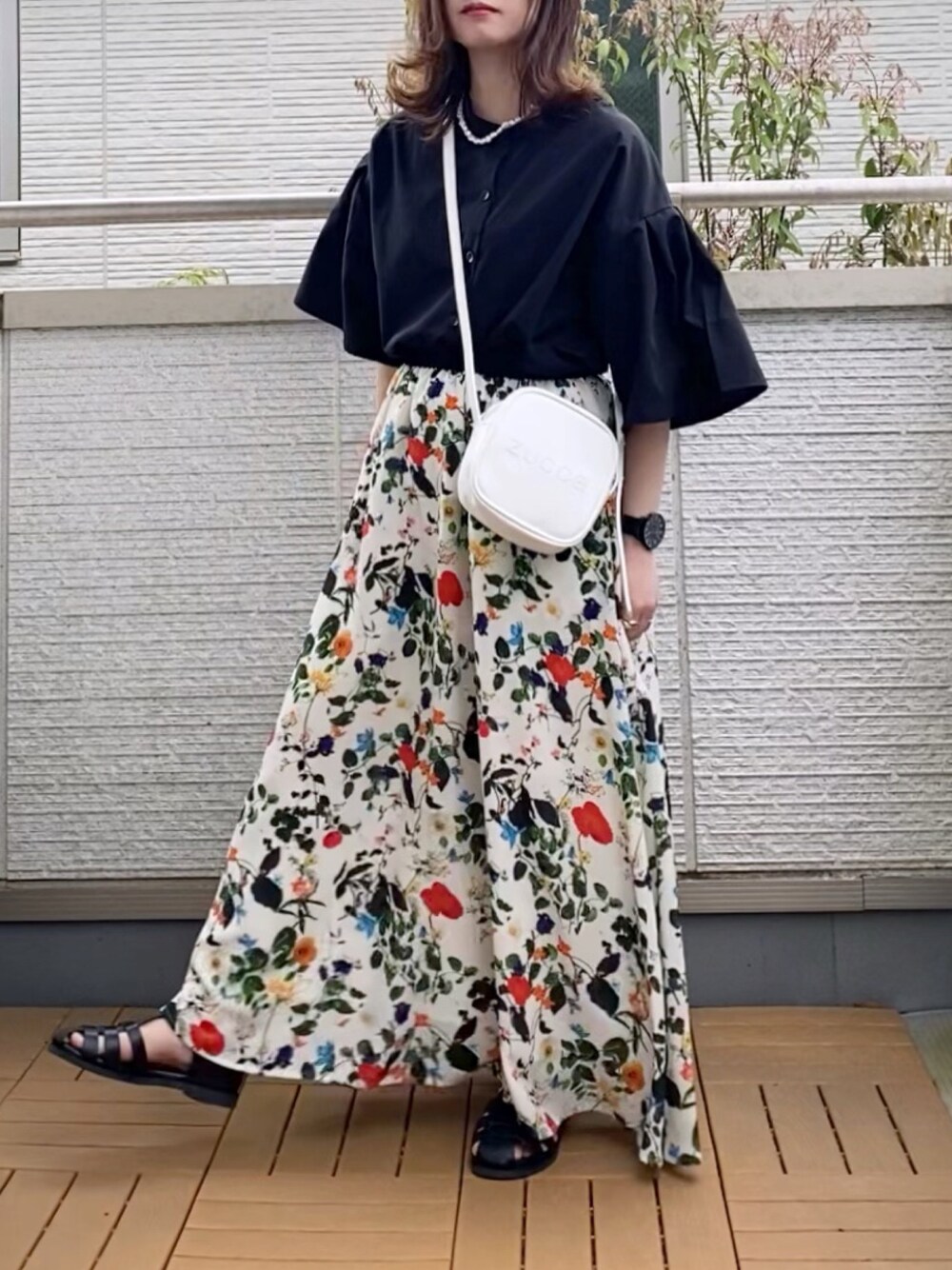 ブラック系のシャツ/ブラウス、ホワイト系のスカート、ホワイト系のショルダーバッグを着用したレディースの春コーディネートの1枚目の写真