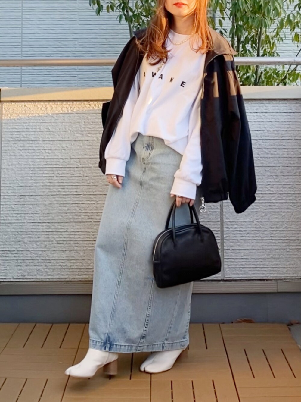 ホワイト系のTシャツ/カットソー、ブラック系のその他アウター、ブルー系のデニムスカートを着用したレディースの春コーディネートの1枚目の写真