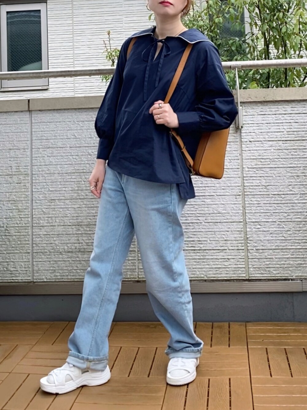 ブルー系のシャツ/ブラウス、ブルー系のデニムパンツ、イエロー系のバックパック/リュックを着用したレディースの春コーディネートの1枚目の写真
