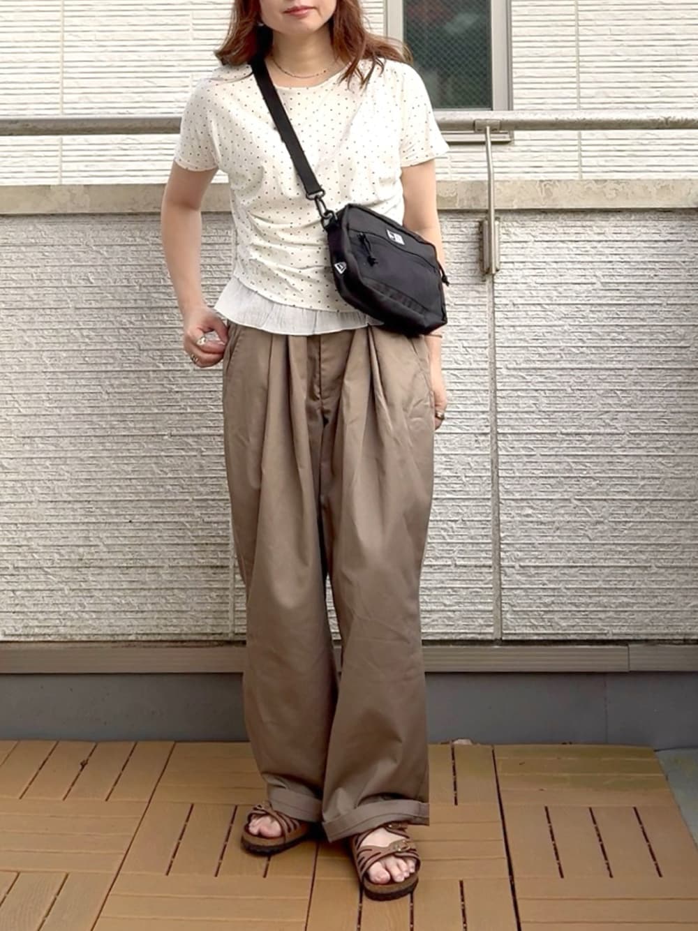 ホワイト系のTシャツ/カットソー、ブラック系のショルダーバッグ、ベージュ系のチノパンツを着用したレディースの夏コーディネートの1枚目の写真
