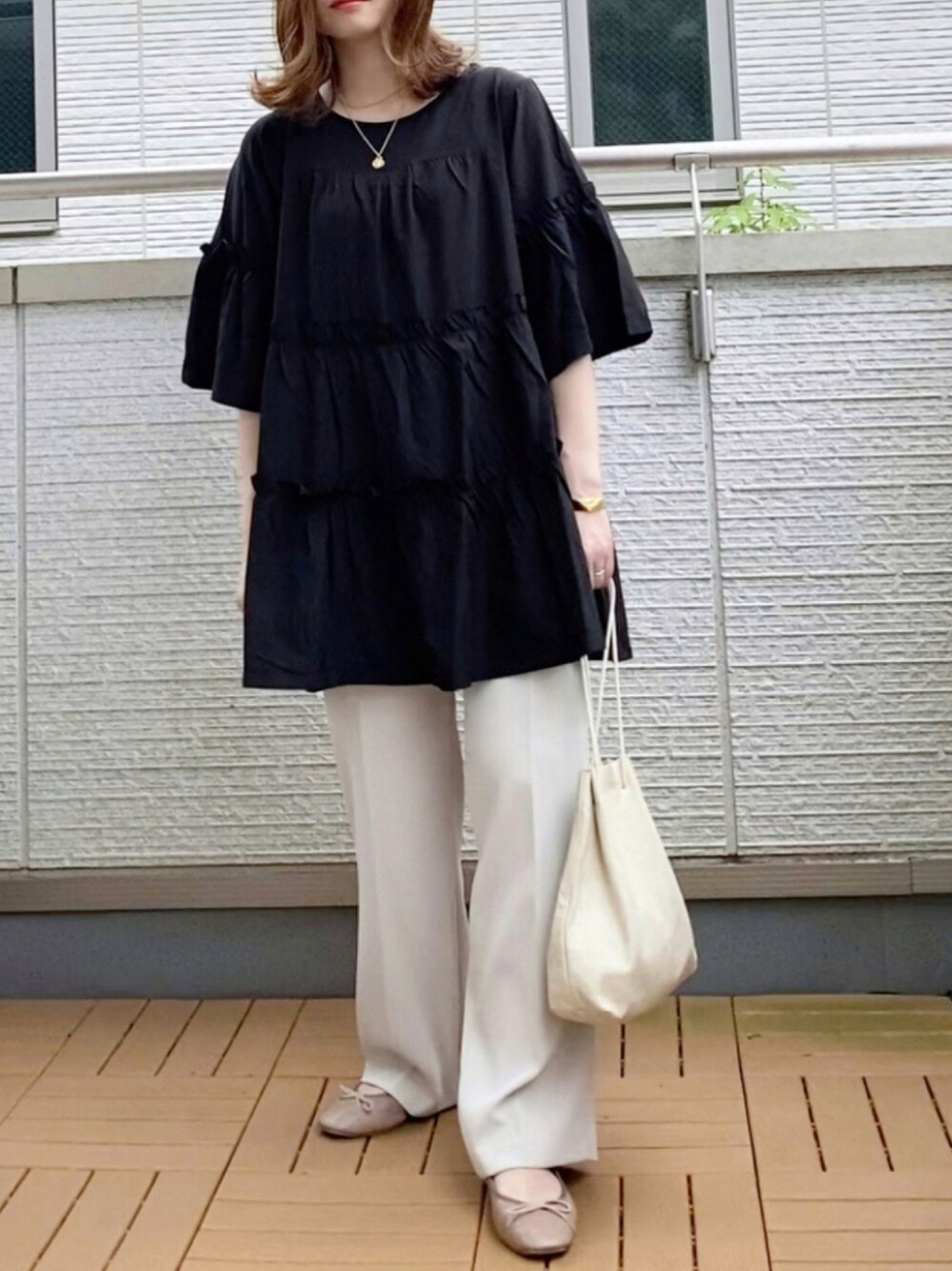 ブラック系のワンピース、ホワイト系のスラックス、ホワイト系のショルダーバッグを着用したレディースの夏コーディネートの1枚目の写真
