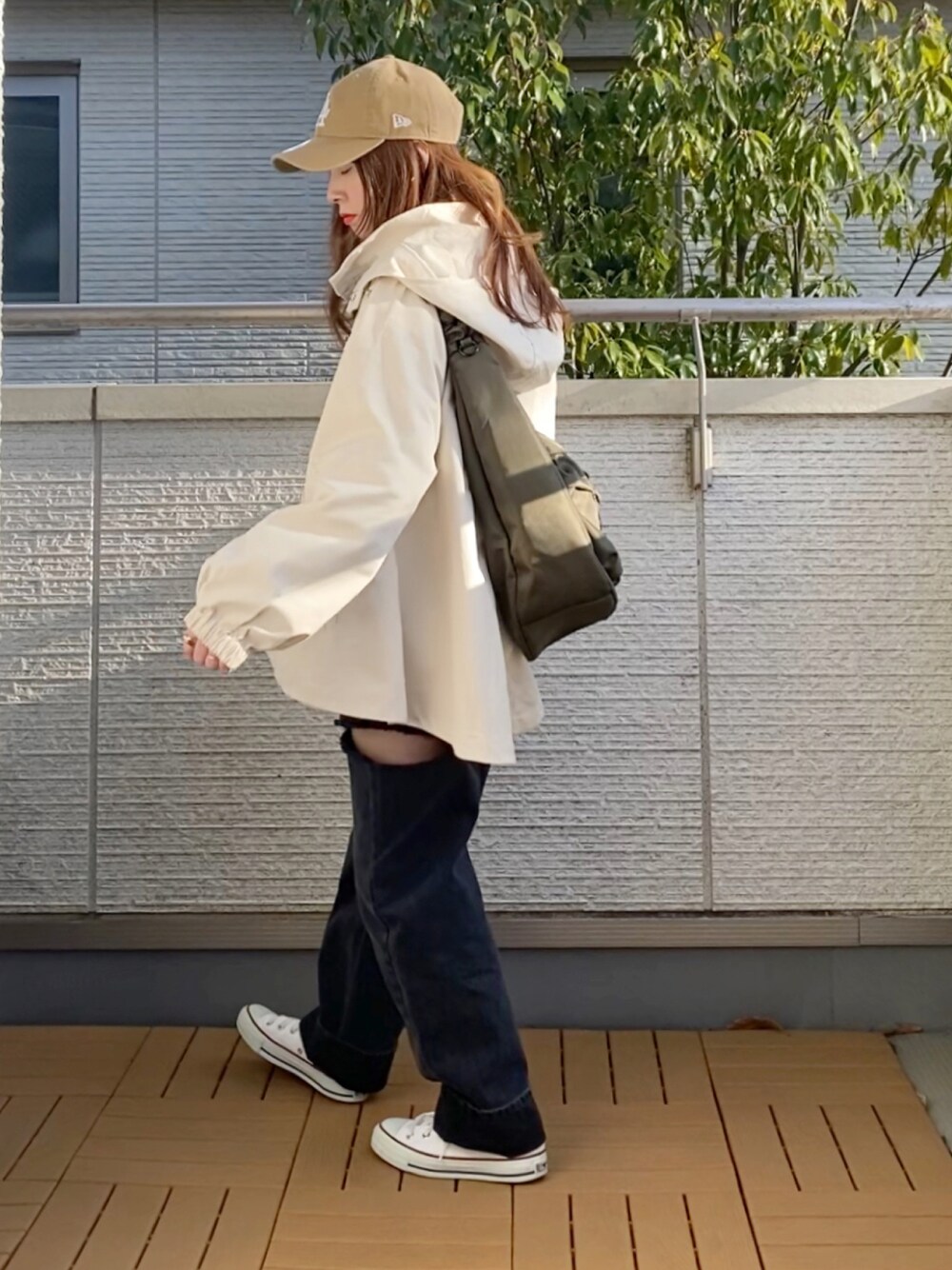 ホワイト系のマウンテンパーカー、ブラック系のTシャツ/カットソー、ブラック系のデニムパンツを着用したレディースの春コーディネートの1枚目の写真