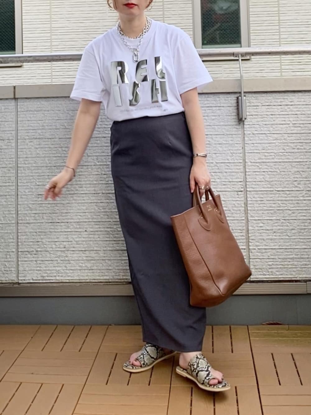 ホワイト系のTシャツ/カットソー、グレー系のスカート、ブラウン系のトートバッグを着用したレディースの夏コーディネートの1枚目の写真
