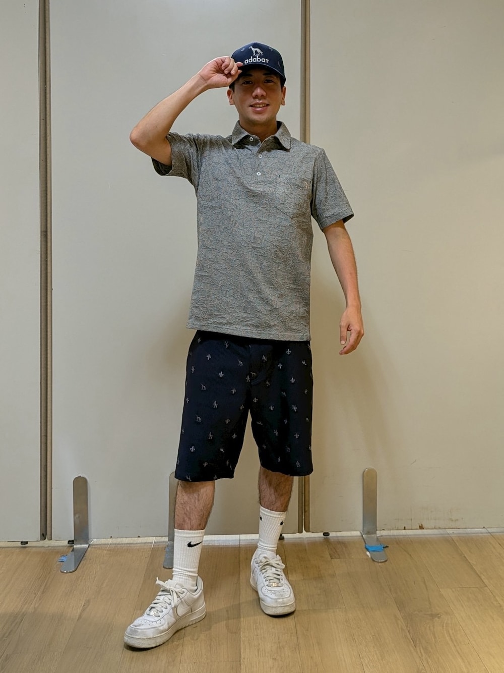 ブラック系のポロシャツ、ブルー系のその他パンツ、ブルー系のキャップを着用したメンズの夏コーディネートの1枚目の写真