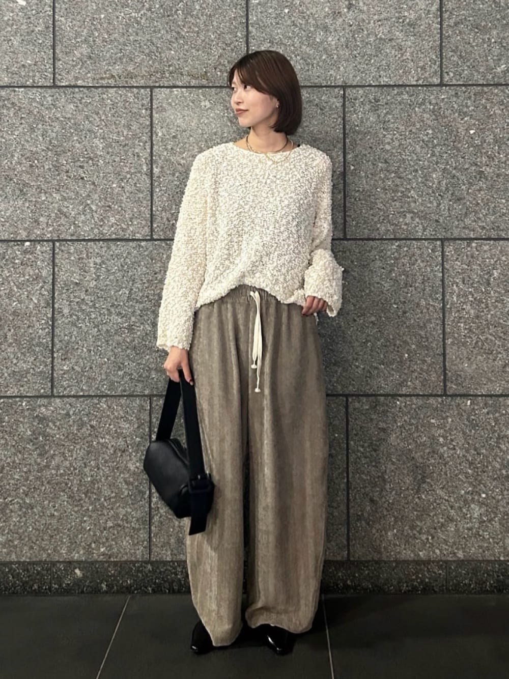 ホワイト系のニット/セーター、ベージュ系のその他パンツ、ブラック系のトートバッグを着用したレディースの秋コーディネートの1枚目の写真