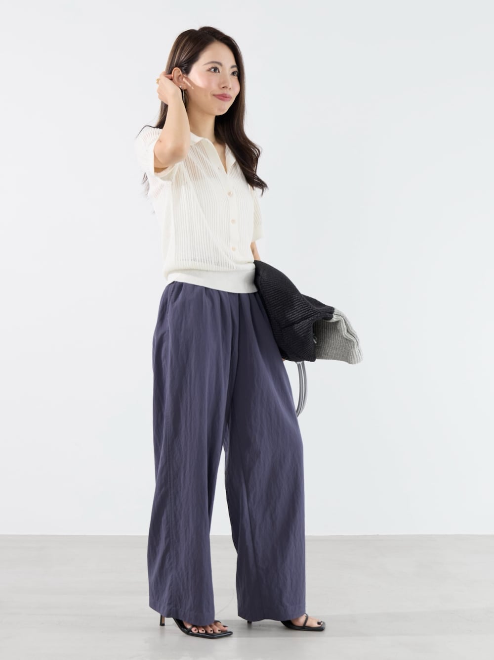 ブルー系のその他パンツ、ホワイト系のニット/セーター、グレー系のトートバッグを着用したレディースの夏コーディネートの1枚目の写真