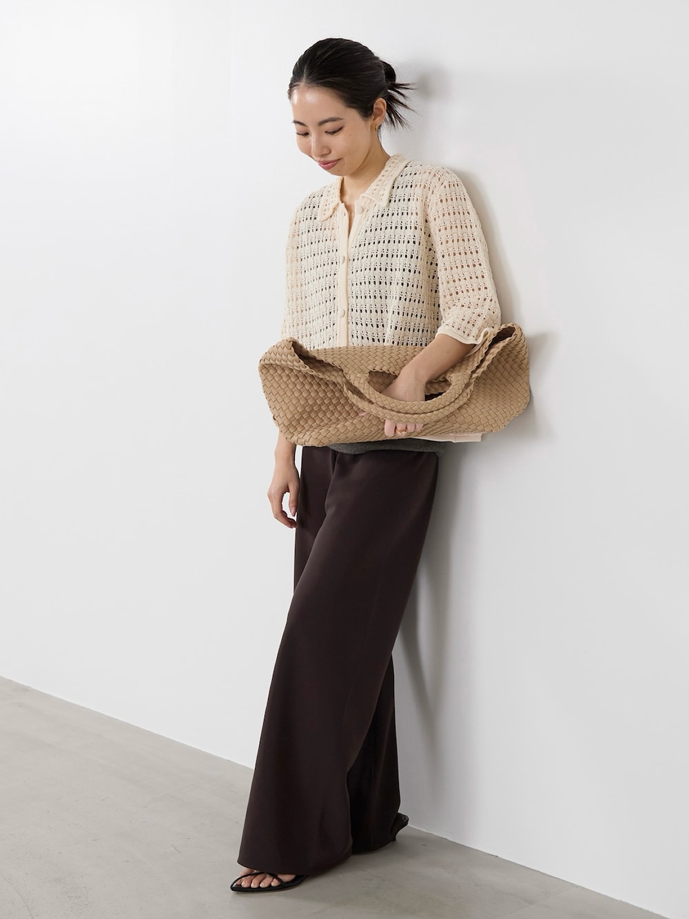 ホワイト系のニット/セーター、イエロー系のショルダーバッグ、ブラウン系のその他パンツを着用したレディースの春コーディネートの1枚目の写真