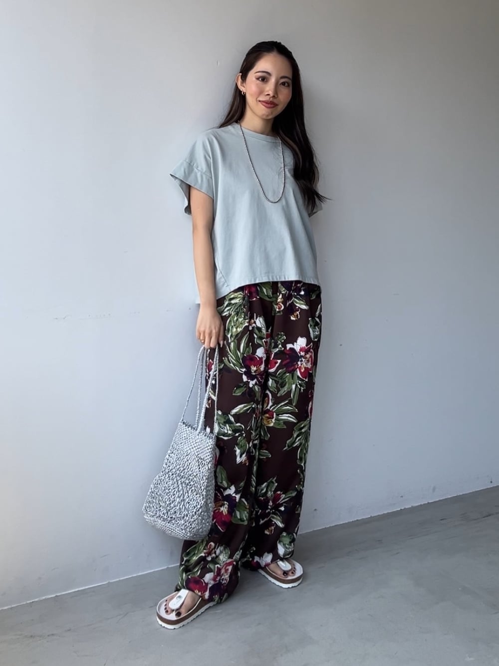 ブラウン系のその他パンツ、グリーン系のTシャツ/カットソー、シルバー系のハンドバッグを着用したレディースの夏コーディネートの1枚目の写真