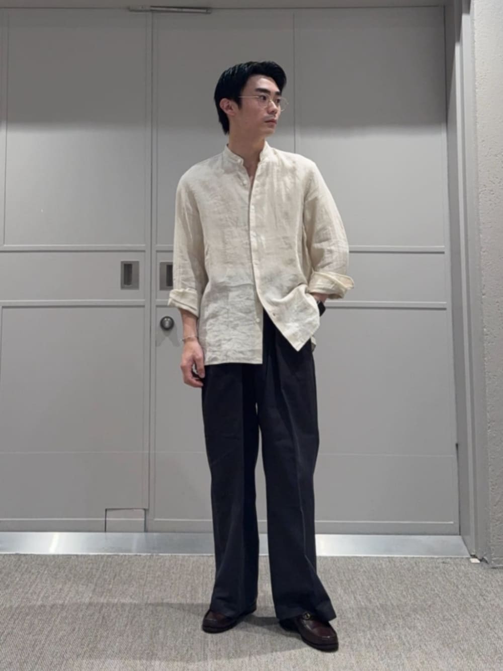 グレー系のチノパンツ、ベージュ系のシャツ/ブラウス、ブラウン系のローファーを着用したメンズの秋コーディネートの1枚目の写真