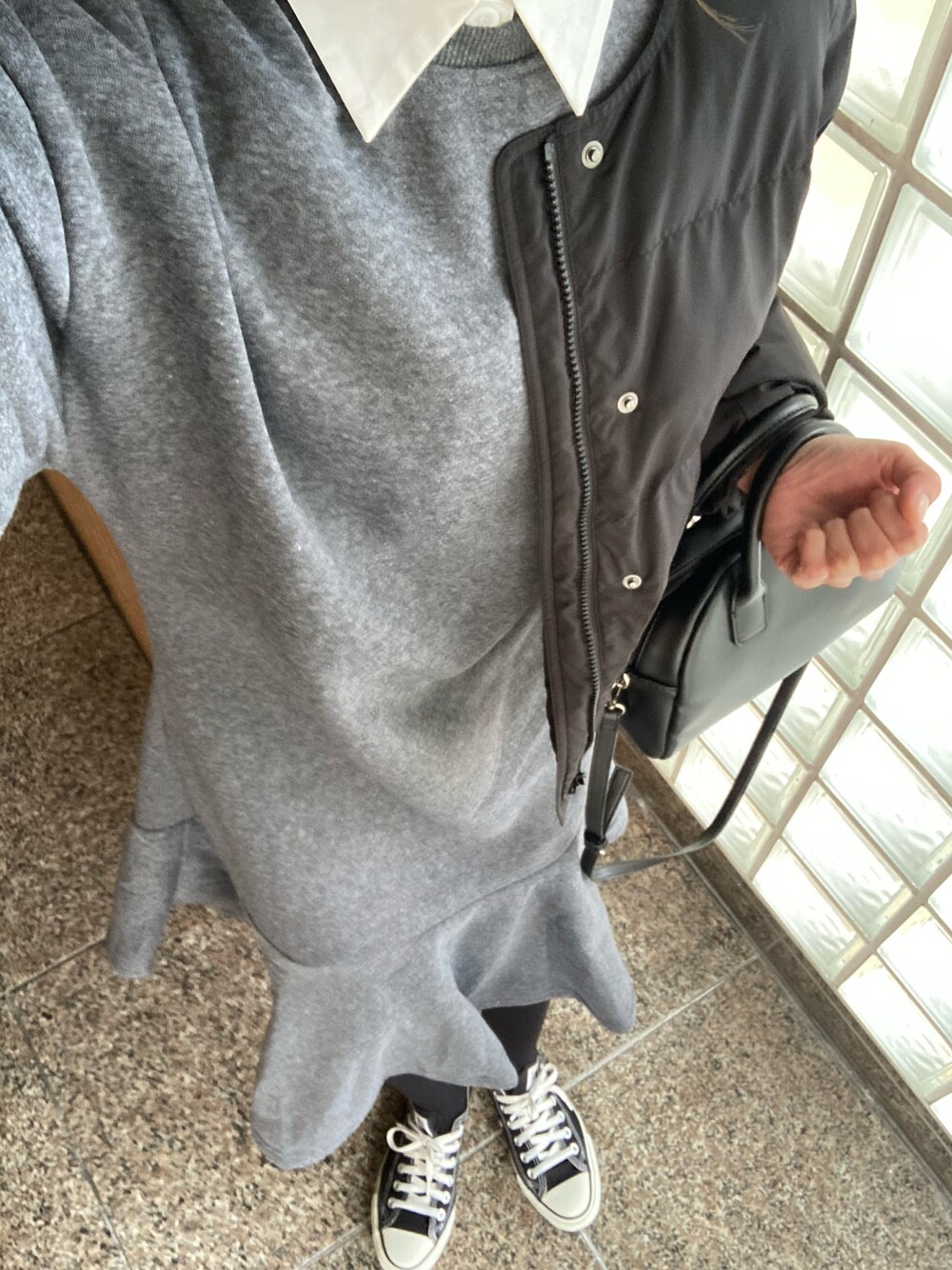 ブラック系のダウンジャケット/コート、グレー系のワンピース、ブラック系のショルダーバッグを着用したレディースの冬コーディネートの1枚目の写真