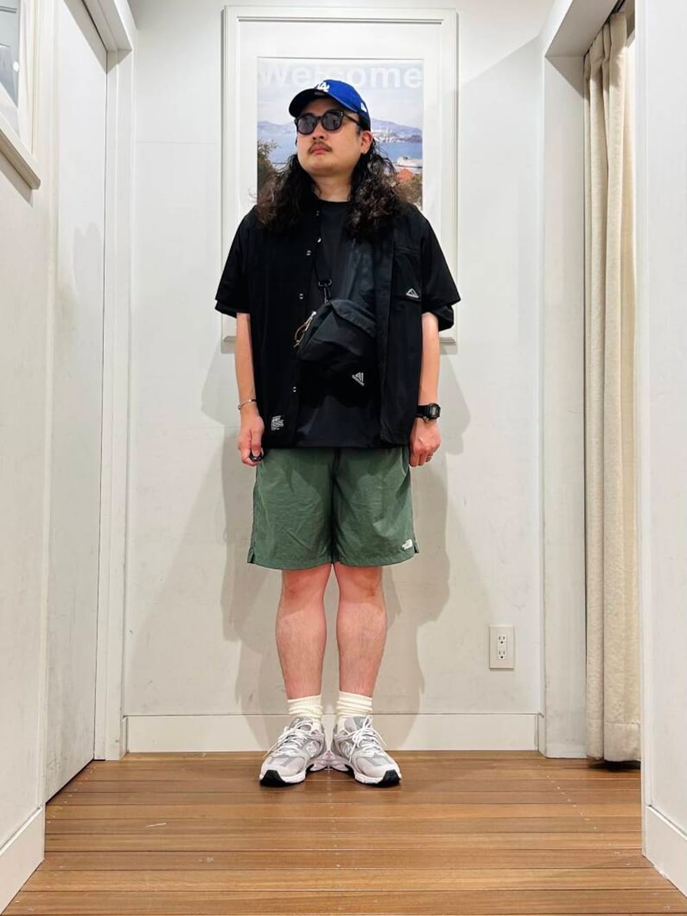グリーン系のその他パンツ、グレー系のスニーカー、ブラック系のショルダーバッグを着用したメンズの春コーディネートの1枚目の写真