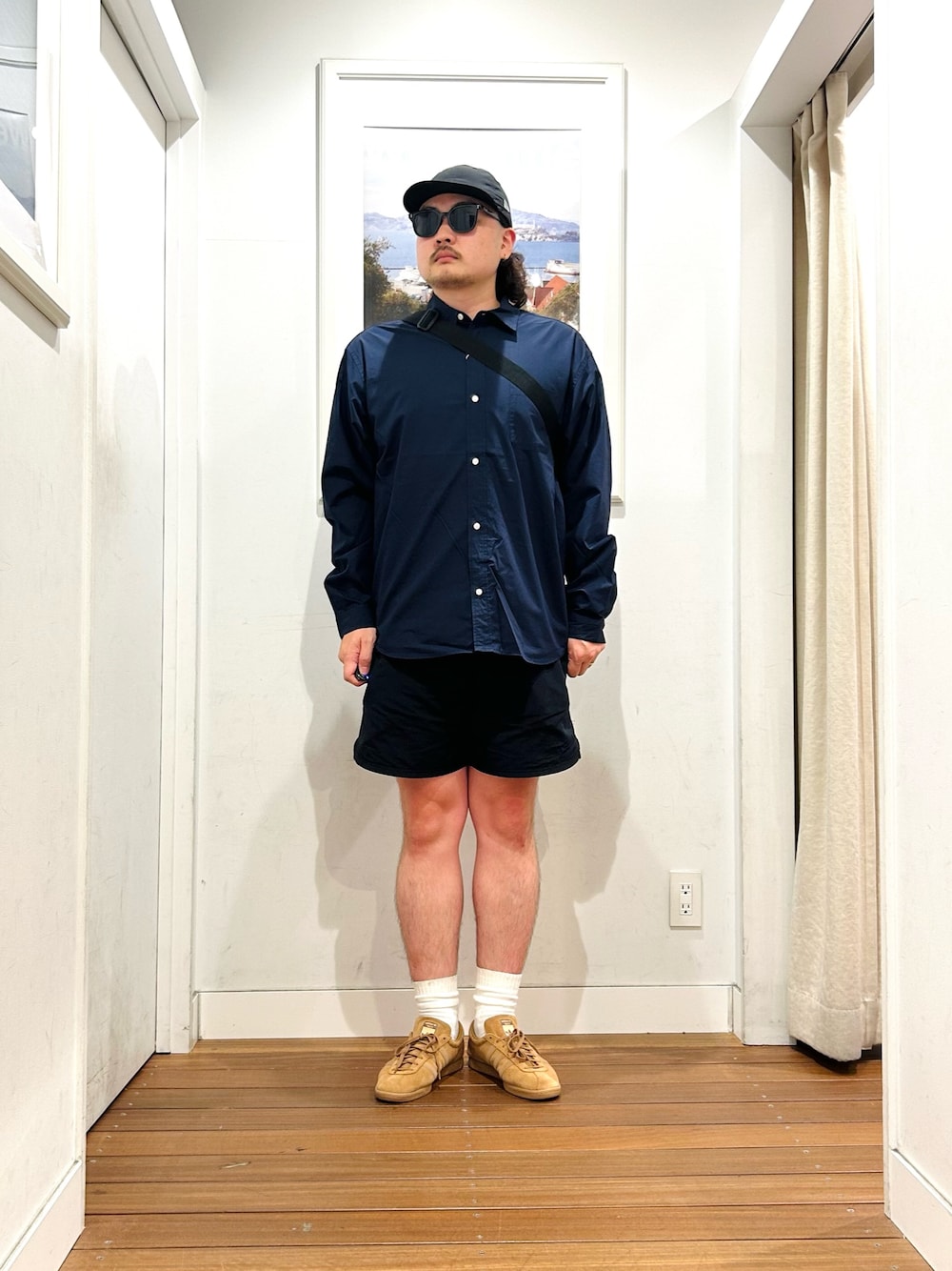 グレー系のショルダーバッグ、ブルー系のシャツ/ブラウス、ブラウン系のスニーカーを着用したメンズの秋コーディネートの1枚目の写真