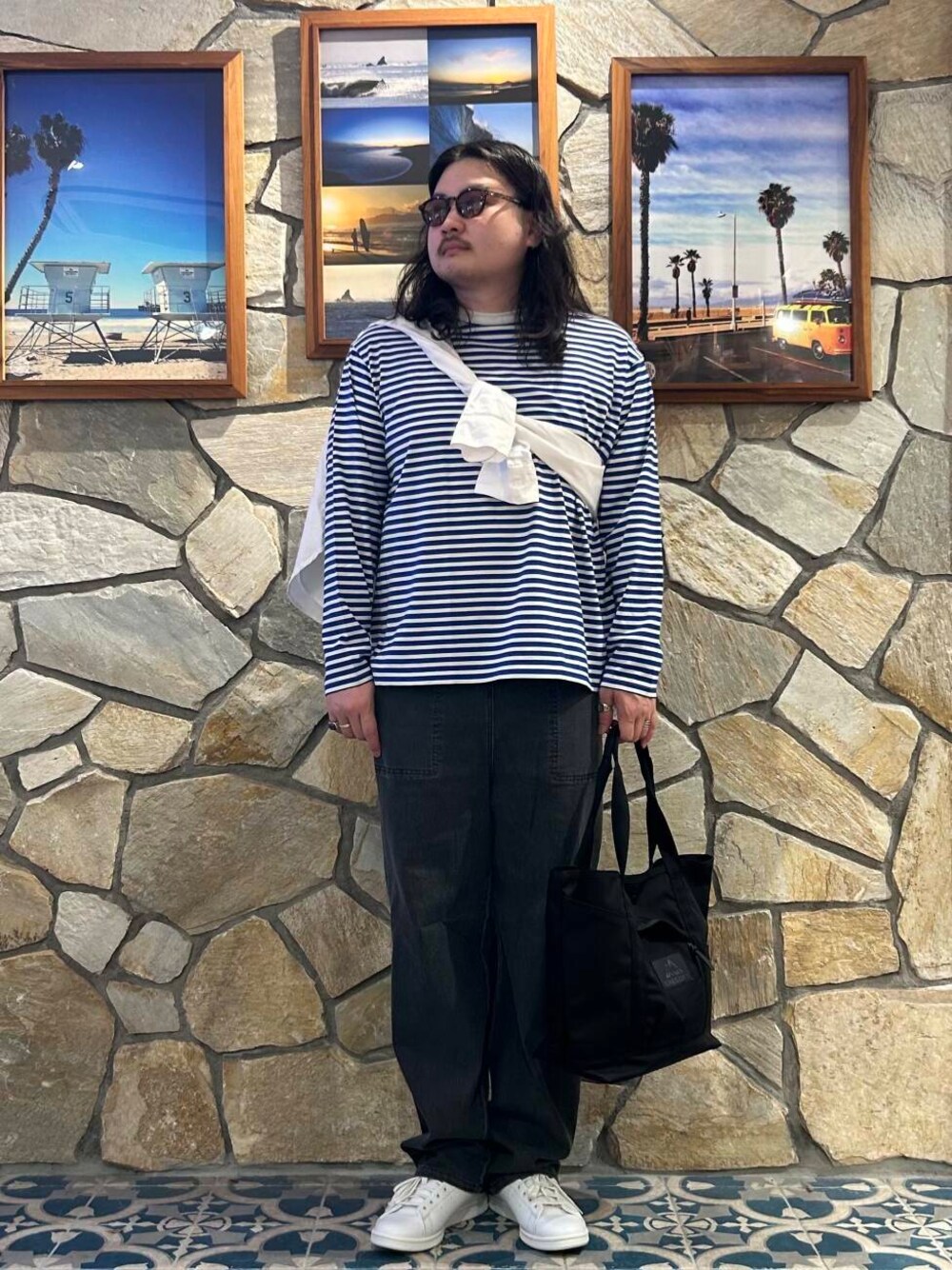 ホワイト系のスニーカー、ブルー系のTシャツ/カットソー、ブラック系のトートバッグを着用したメンズの夏コーディネートの1枚目の写真