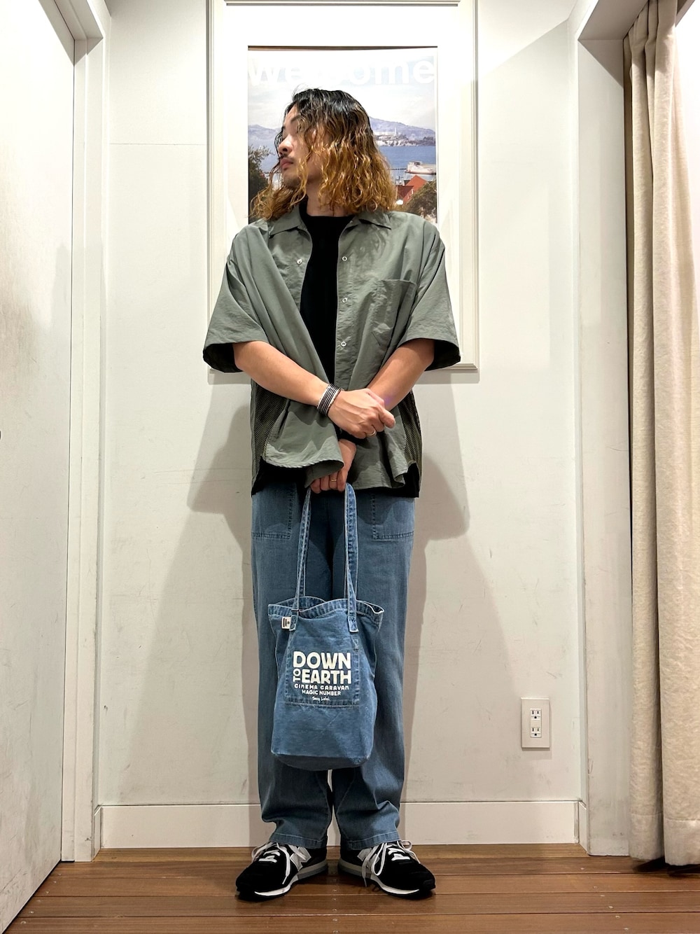 ブラック系のスニーカー、ブラック系のTシャツ/カットソー、ブルー系のデニムパンツを着用したメンズの春コーディネートの1枚目の写真