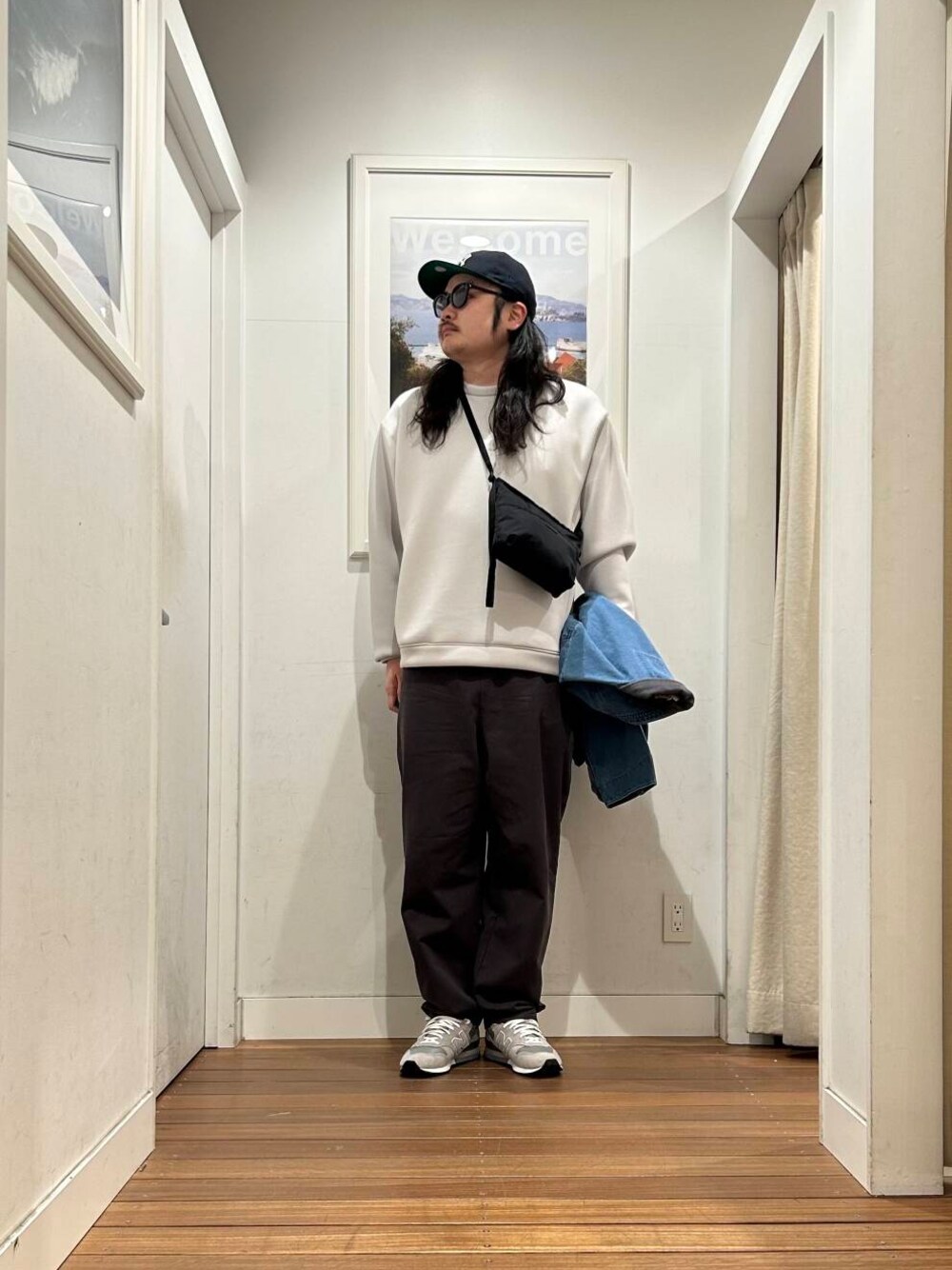ブラック系のショルダーバッグ、ブルー系のカバーオール、グレー系のスニーカーを着用したメンズの冬コーディネートの1枚目の写真