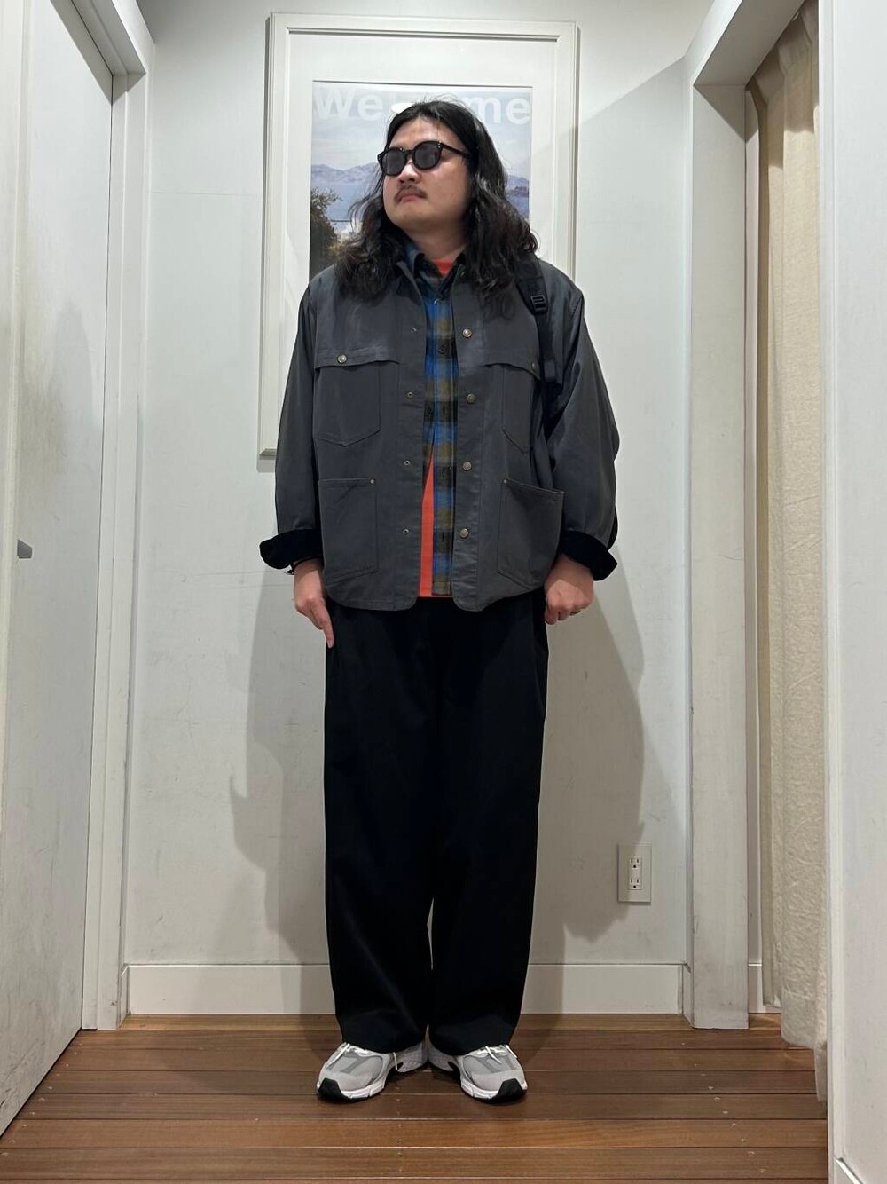 ブラック系のその他パンツ、オレンジ系のTシャツ/カットソー、グレー系のスニーカーを着用したメンズの秋コーディネートの1枚目の写真