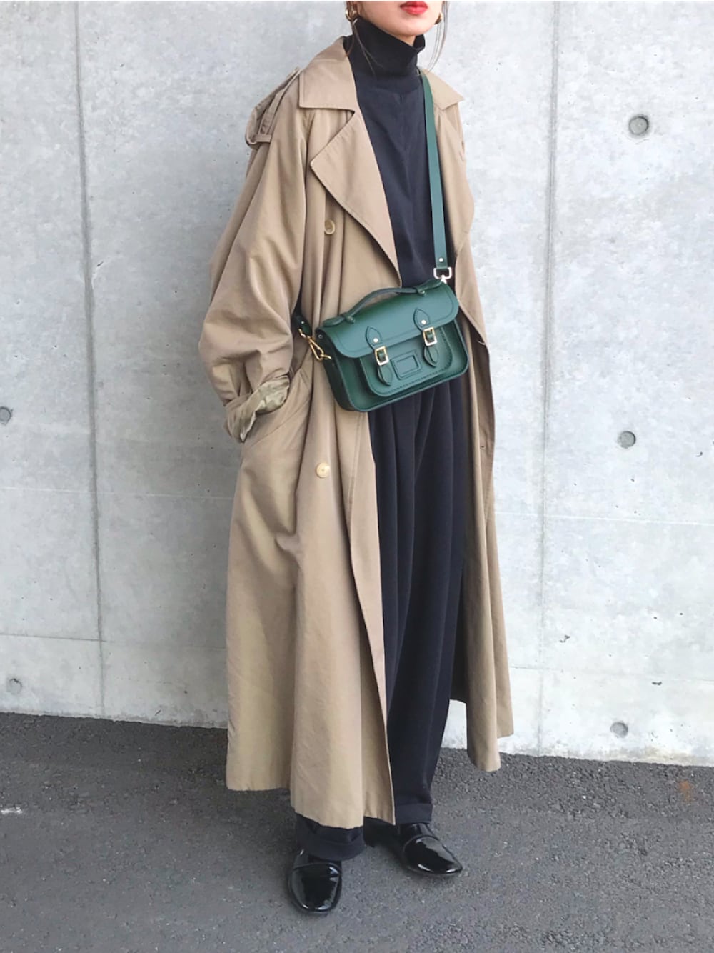 ベージュ系のトレンチコート、ブラック系のトップス、ブラック系のパンツを着用したレディースの春コーディネートの1枚目の写真