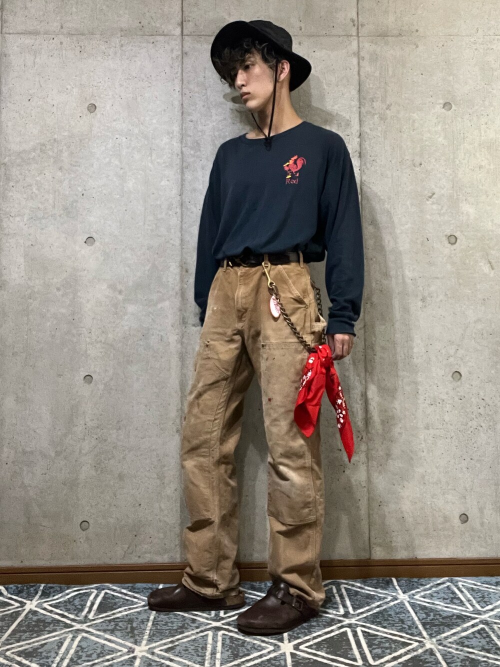 ブルー系のTシャツ/カットソー、ベージュ系のその他パンツ、ブラウン系のサンダルを着用したメンズの秋コーディネートの1枚目の写真