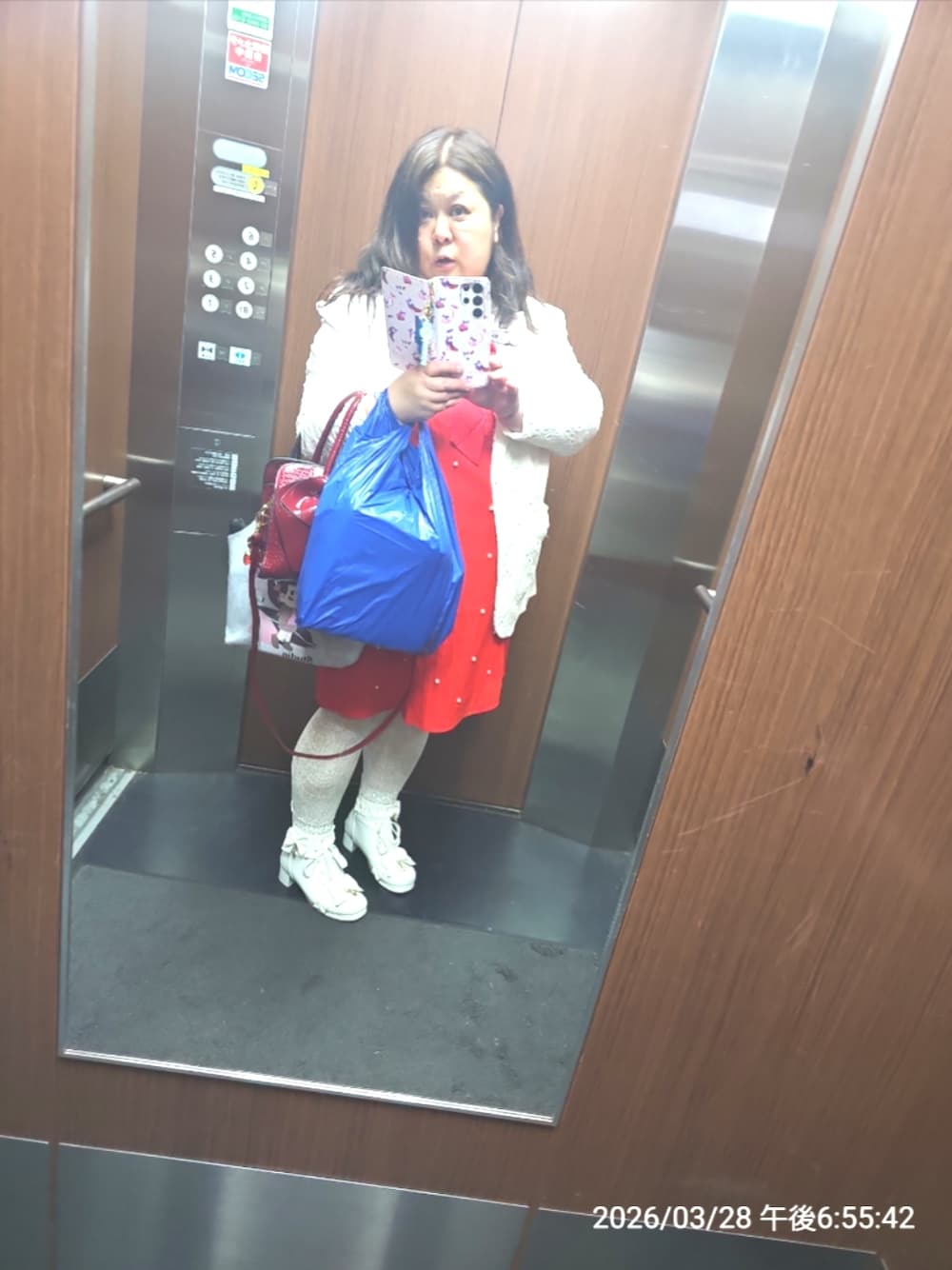 レッド系のワンピース、ホワイト系のテーラードジャケット、ホワイト系のブーツを着用したレディースの春コーディネートの1枚目の写真