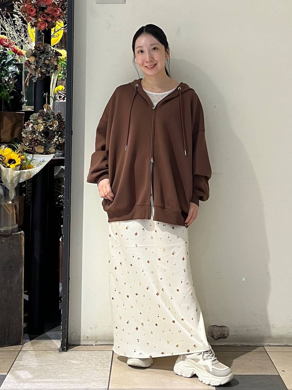 ホワイト系のTシャツ/カットソー、ホワイト系のスカート、シルバー系のタンクトップを着用したレディースの秋コーディネートの1枚目の写真