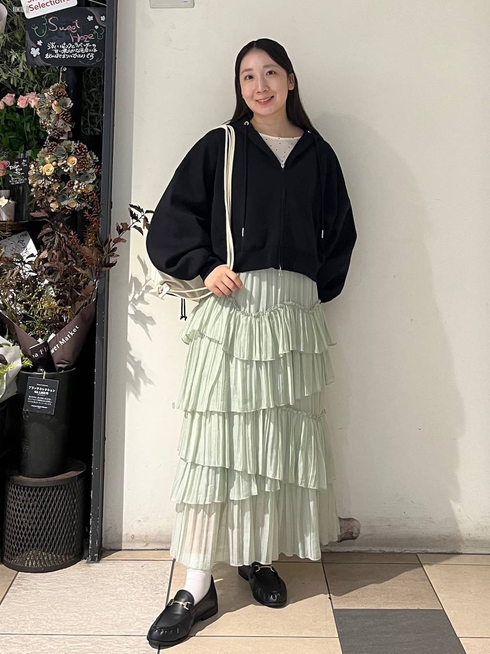 グリーン系のスカート、ブラック系のローファー、その他のTシャツ/カットソーを着用したレディースの秋コーディネートの1枚目の写真
