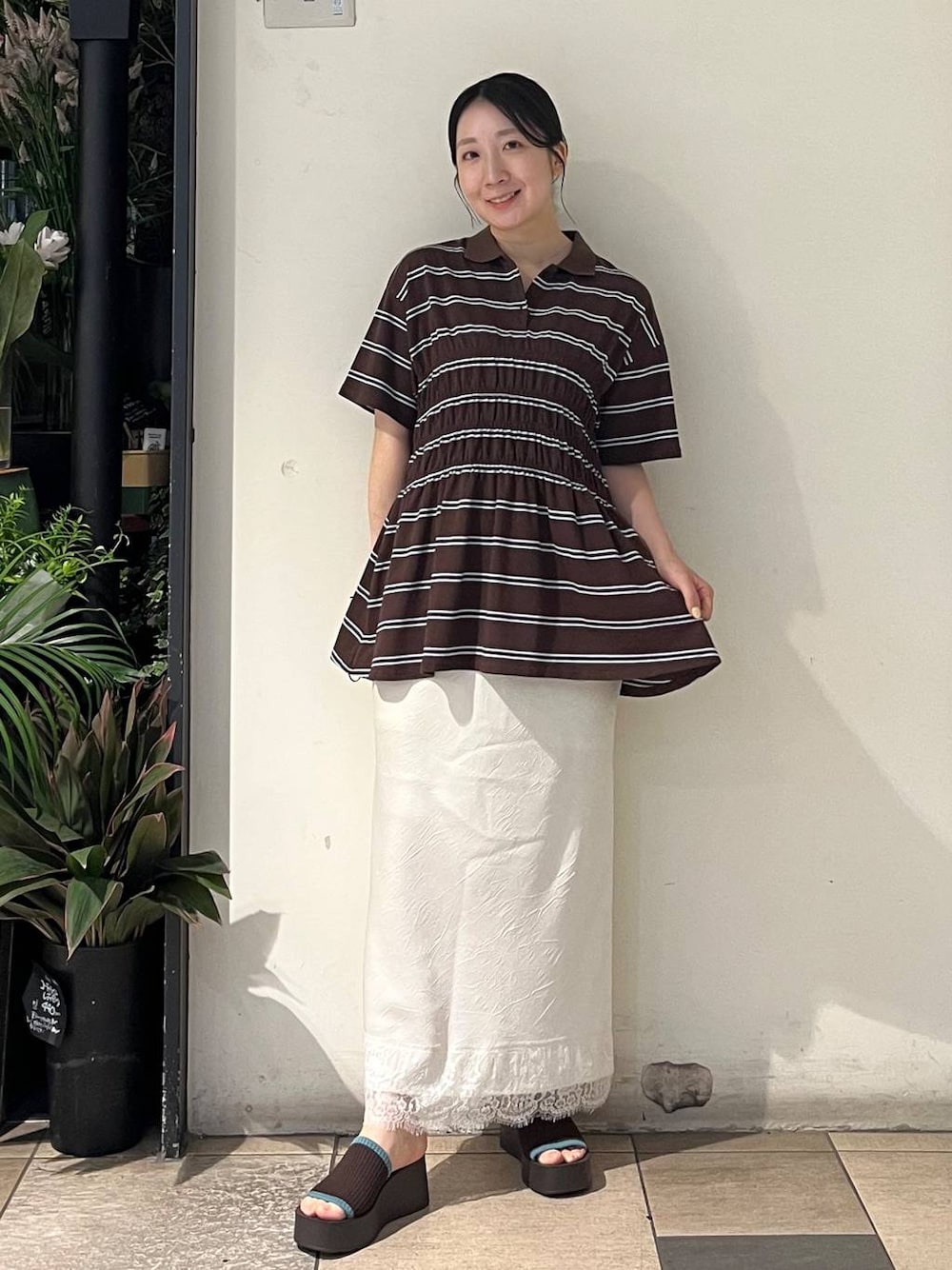 ブラウン系のサンダル、ホワイト系のスカート、ブラウン系のTシャツ/カットソーを着用したレディースの夏コーディネートの1枚目の写真