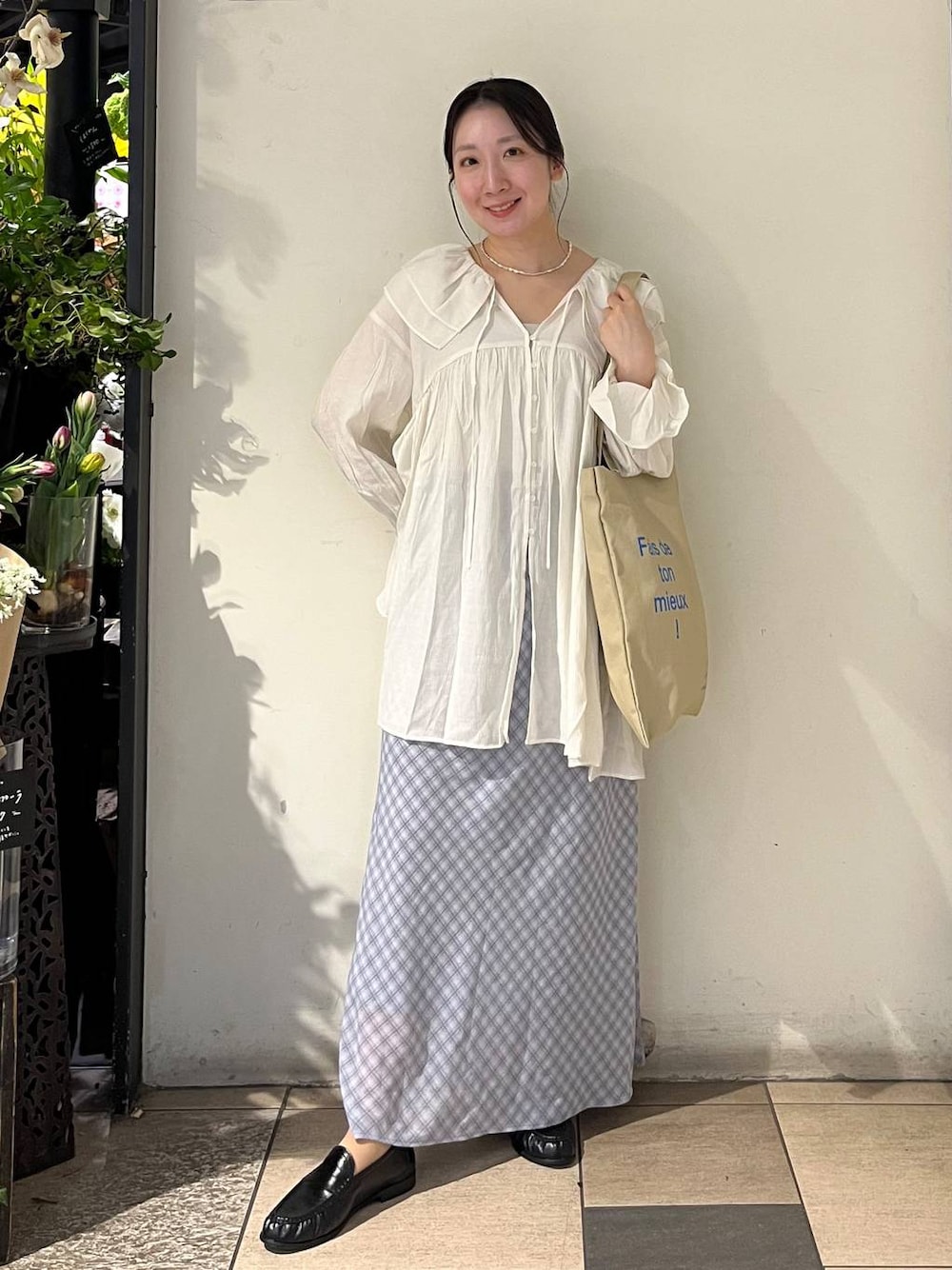 シルバー系のタンクトップ、ベージュ系のトートバッグ、ブラック系のローファーを着用したレディースの春コーディネートの1枚目の写真