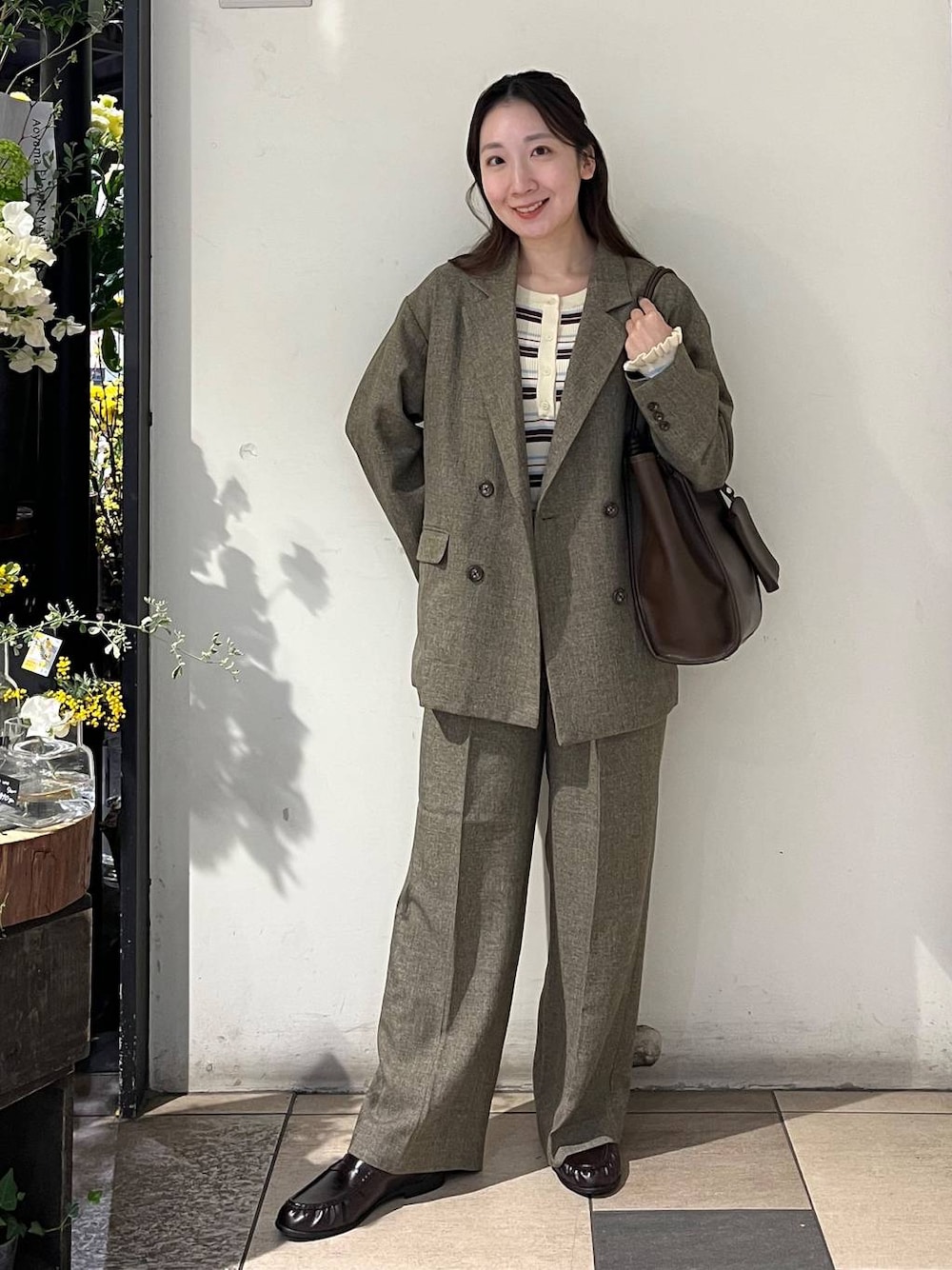 ブラウン系のテーラードジャケット、ブラウン系のデニムパンツ、ブラウン系のローファーを着用したレディースの春コーディネートの1枚目の写真