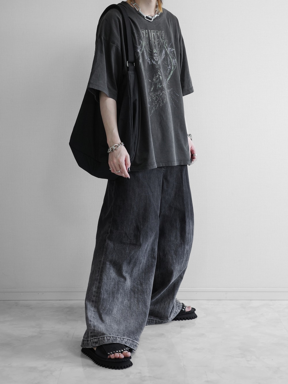 グレー系のTシャツ/カットソー、ブラック系のデニムパンツ、ブラック系のサンダルを着用したメンズの春コーディネートの1枚目の写真