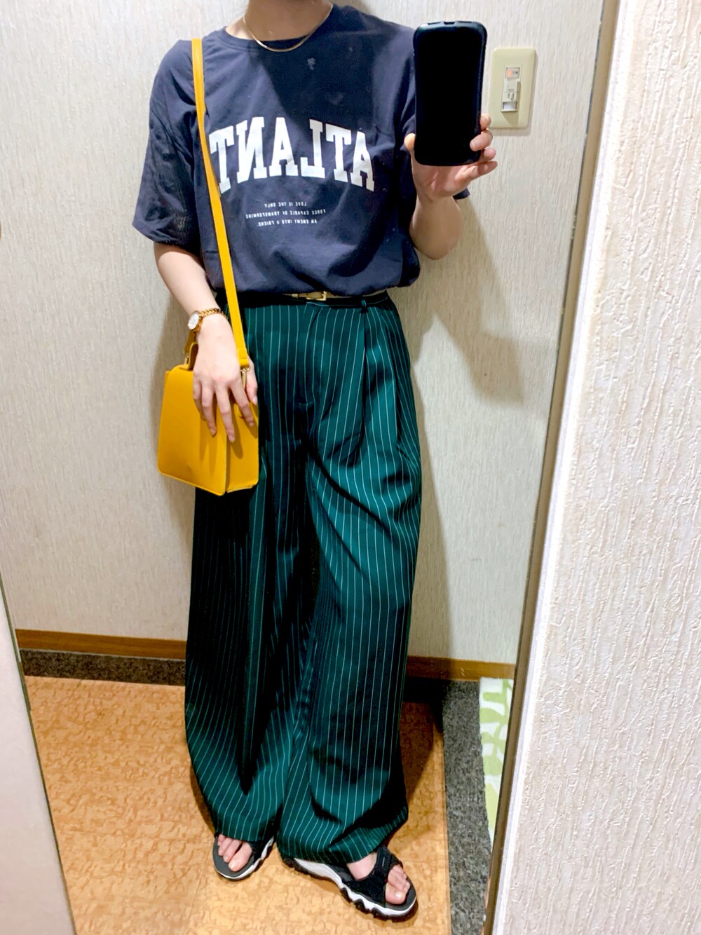 グレー系のTシャツ/カットソー、グリーン系のパンツ、イエロー系のショルダーバッグを着用したレディースの夏コーディネートの1枚目の写真