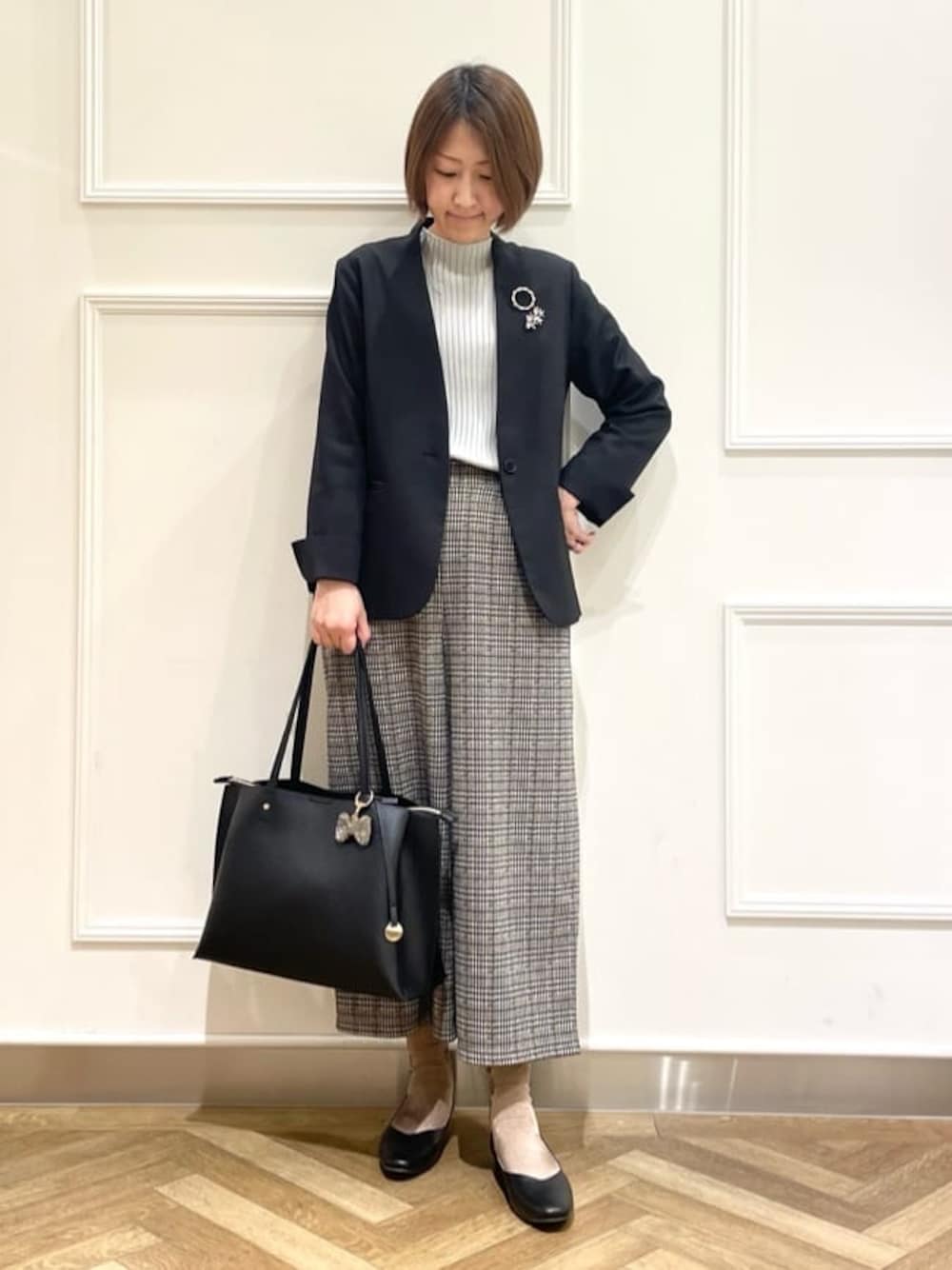 ブラック系のノーカラージャケット、グレー系のニット/セーター、ベージュ系のその他パンツを着用したレディースの冬コーディネートの1枚目の写真
